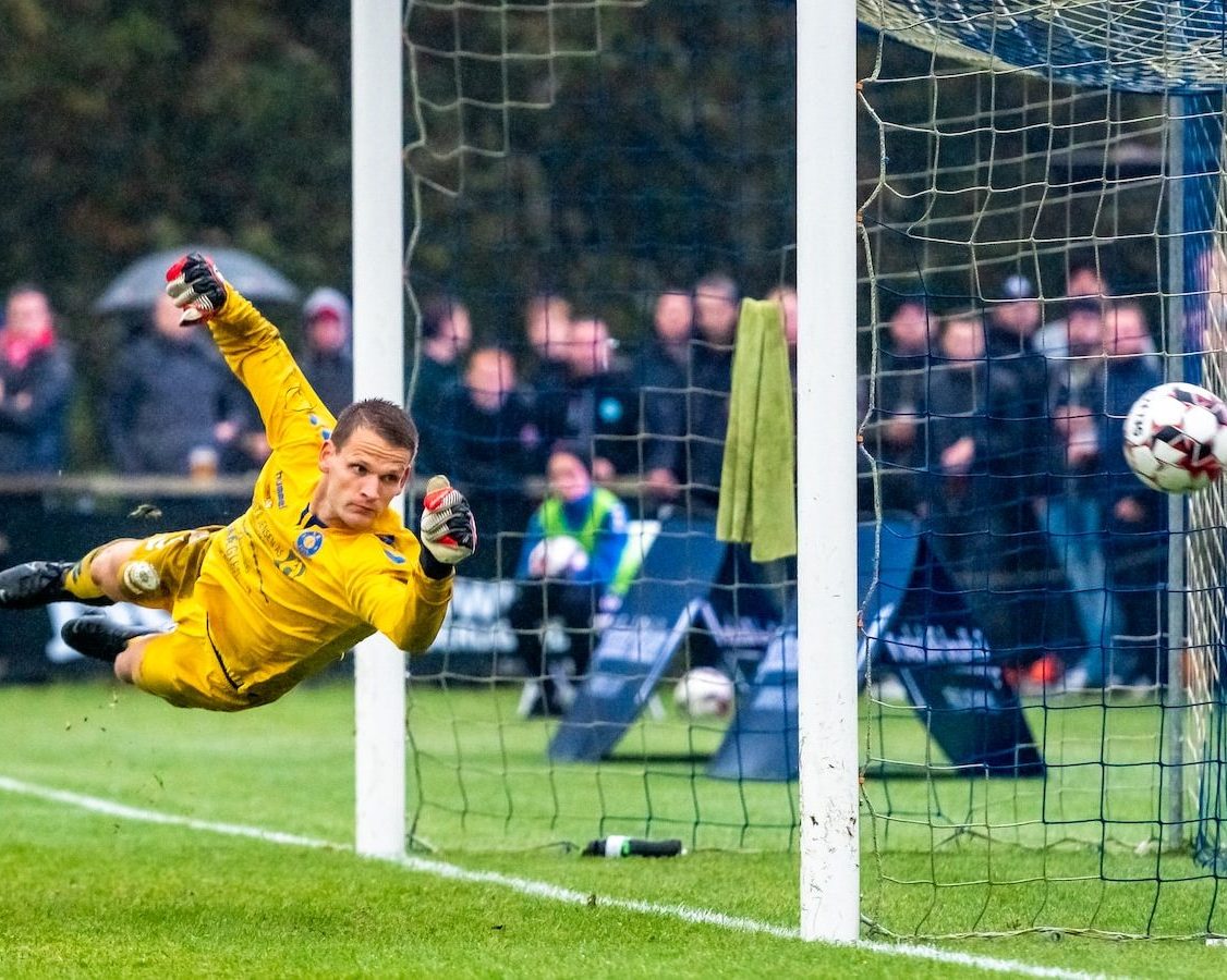 man in yellow long sleeve shirt and yellow pants playing soccer